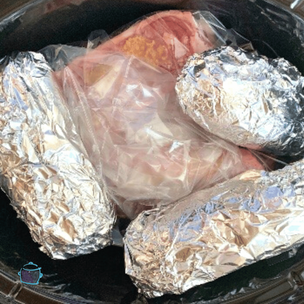 raw steak and potatoes in a slow cooker