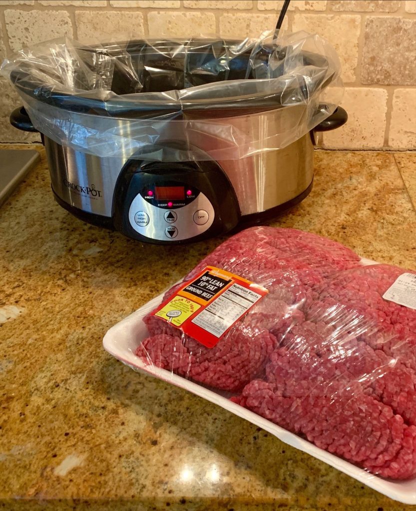 raw ground beef sitting in front of slow cooker