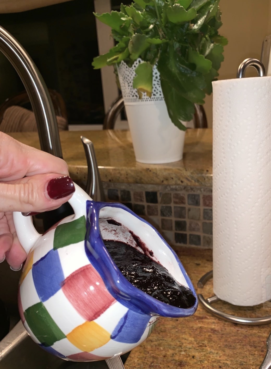 blueberry sauce being poured out of a small pitcher