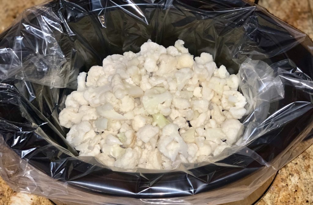 frozen cauliflower in slow cooker vessel