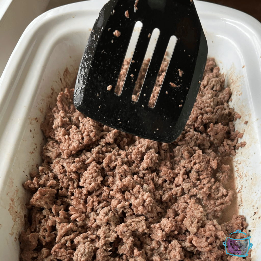 ground beef in a casserole crockpot that is almost fully cooked