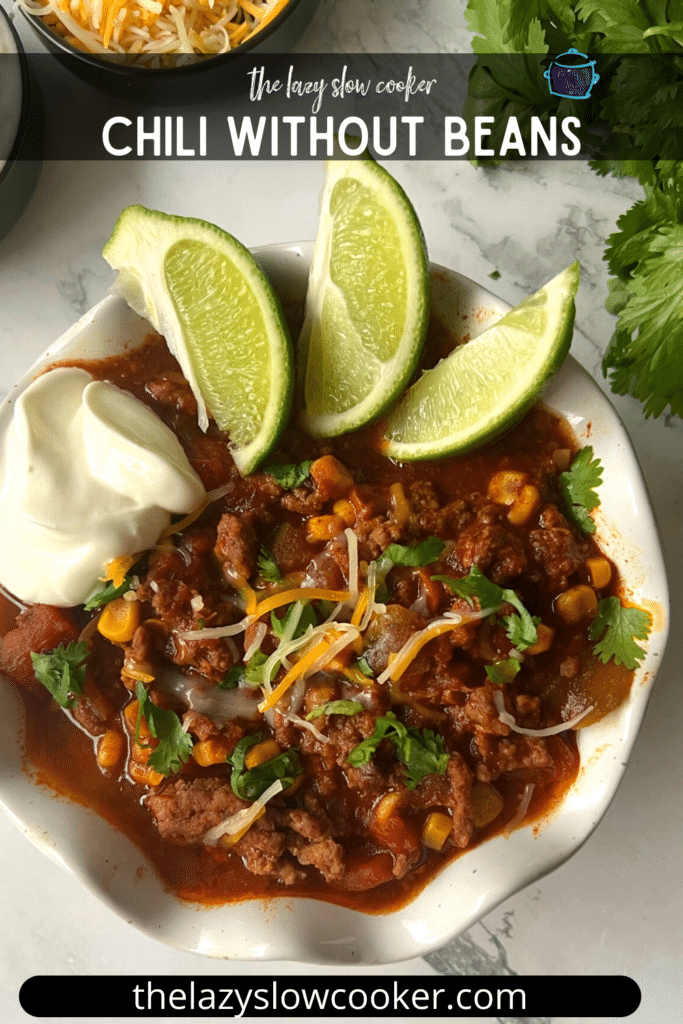 pinterest pin of a bowl of bean free chili with lime wedges and a dollop of sour cream