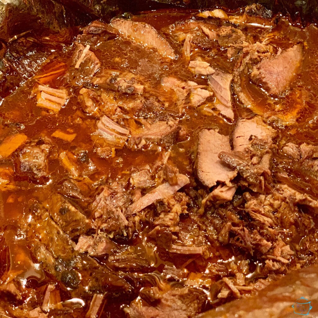 Finished slow cooker brisket in pot after slicing. Ready to fall apart from tenderness