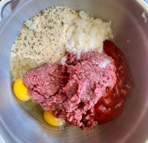 raw meat and other ingredients in mixing bowl
