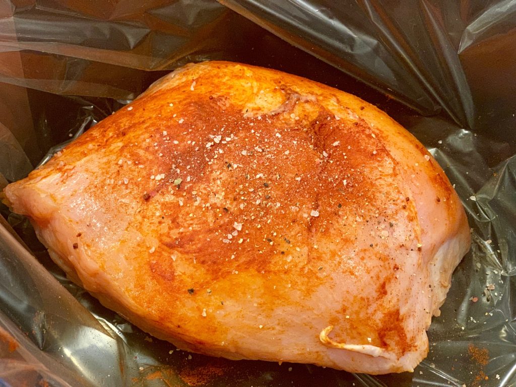 raw turkey breast covered with seasoning