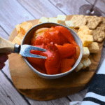roasted red peppers on a cheese plate in a bowl with a fork