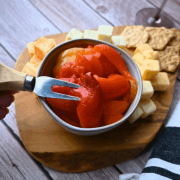 roasted red peppers on a cheese plate in a bowl with a fork