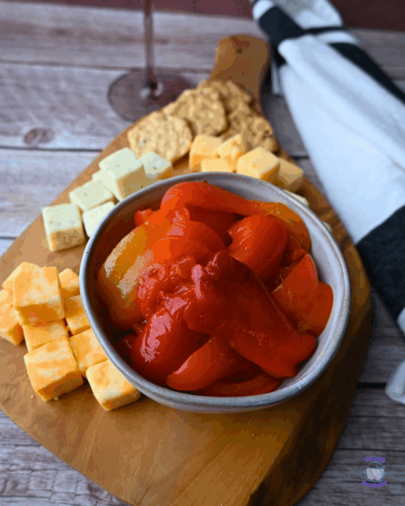 roasted red peppers in a bowl on a cheese board