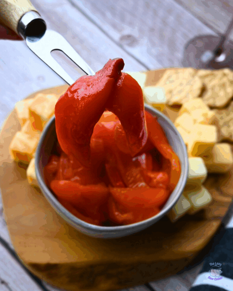 roasted red peppers in a bowl on a cheese board