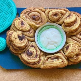 Fully cooked Cinnamon rolls with cream cheese frosting dip in the middle