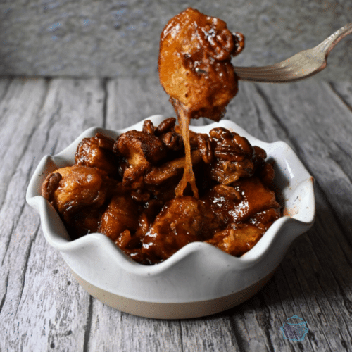 a white wavy bowl with slow cooker gooey caramel sticky bun casserole