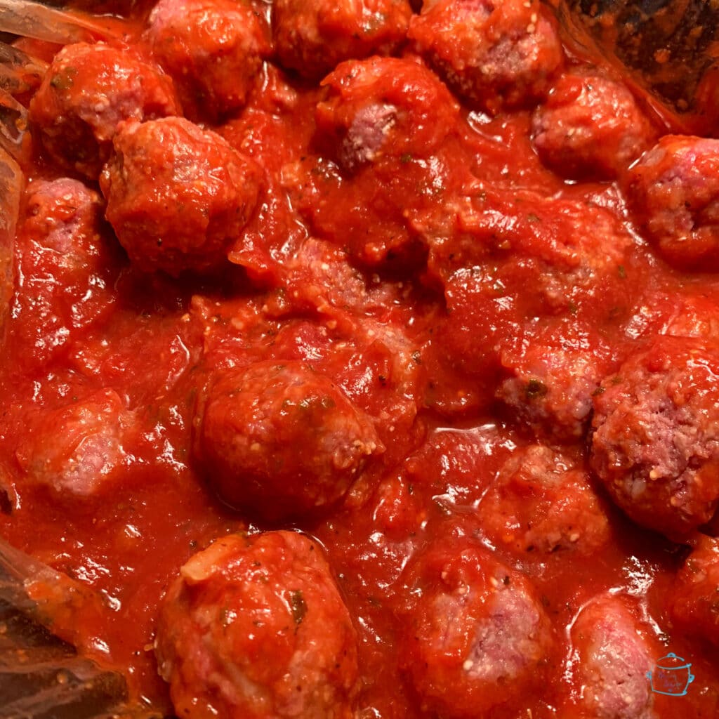 Close up of meatballs in slow cooker prior to cooking