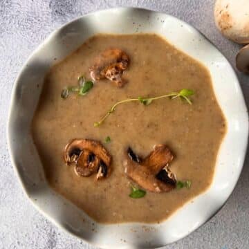 cream of mushroom soup on a ladle held over a crock pot of the same