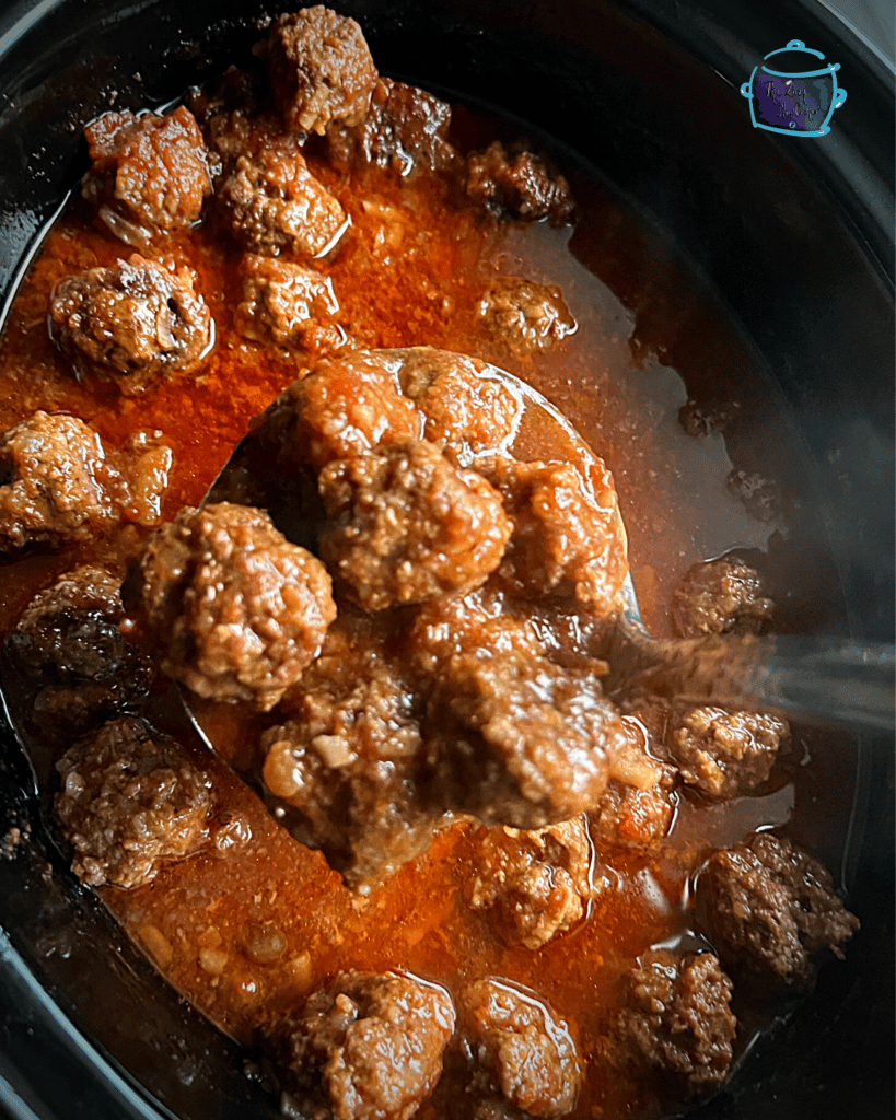 sweet and slow meatballs in slow cooker after cooking. some on a ladel.