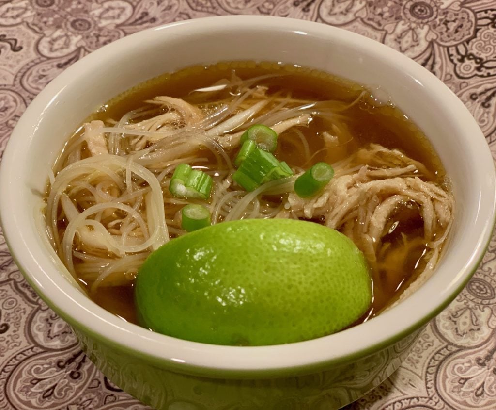 Bowl of pho with lime wedge on top