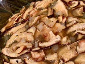 Close up of mushrooms in broth in slow cooker
