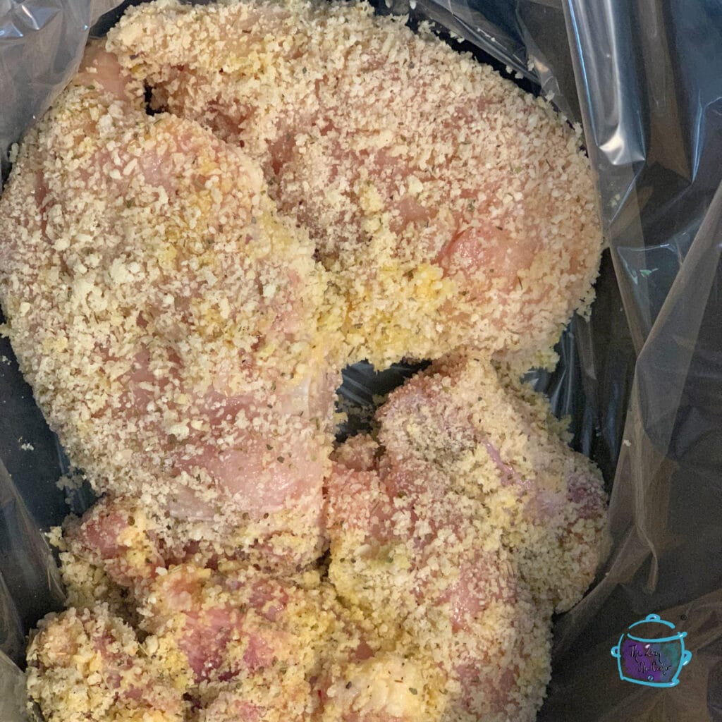 Chicken pieces in a slow cooker covered with breading