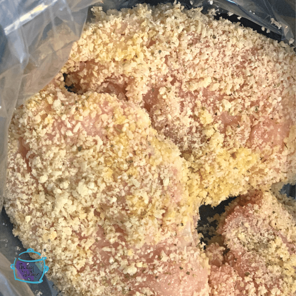 pieces of uncooked chicken parm is slow cooker with breading ready to cook