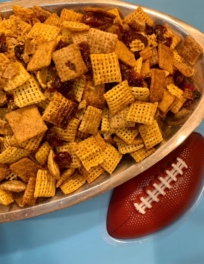 pumpkin pie spiced snack mix in a metal bowl with a plastic football