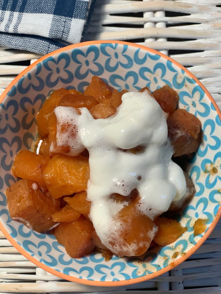 bowl of slow cooker candied sweet potato topped with melted marshmallows