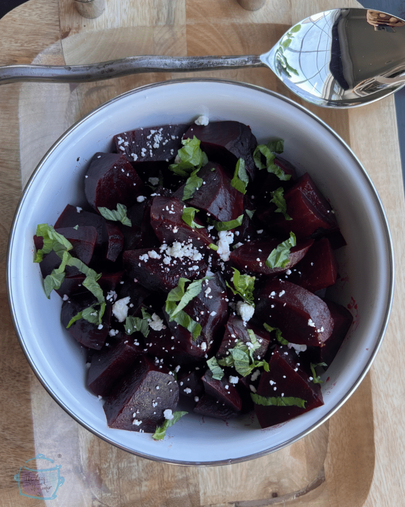 Slow Cooker roasted beets in a bowl topped with chopped herbs