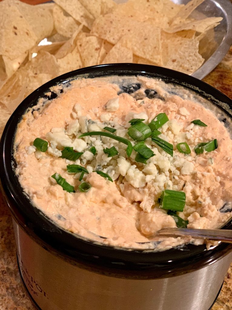 chicken buffalo dip in lil dipper model Crockpot topped with crumbled blue cheese and green onion.  