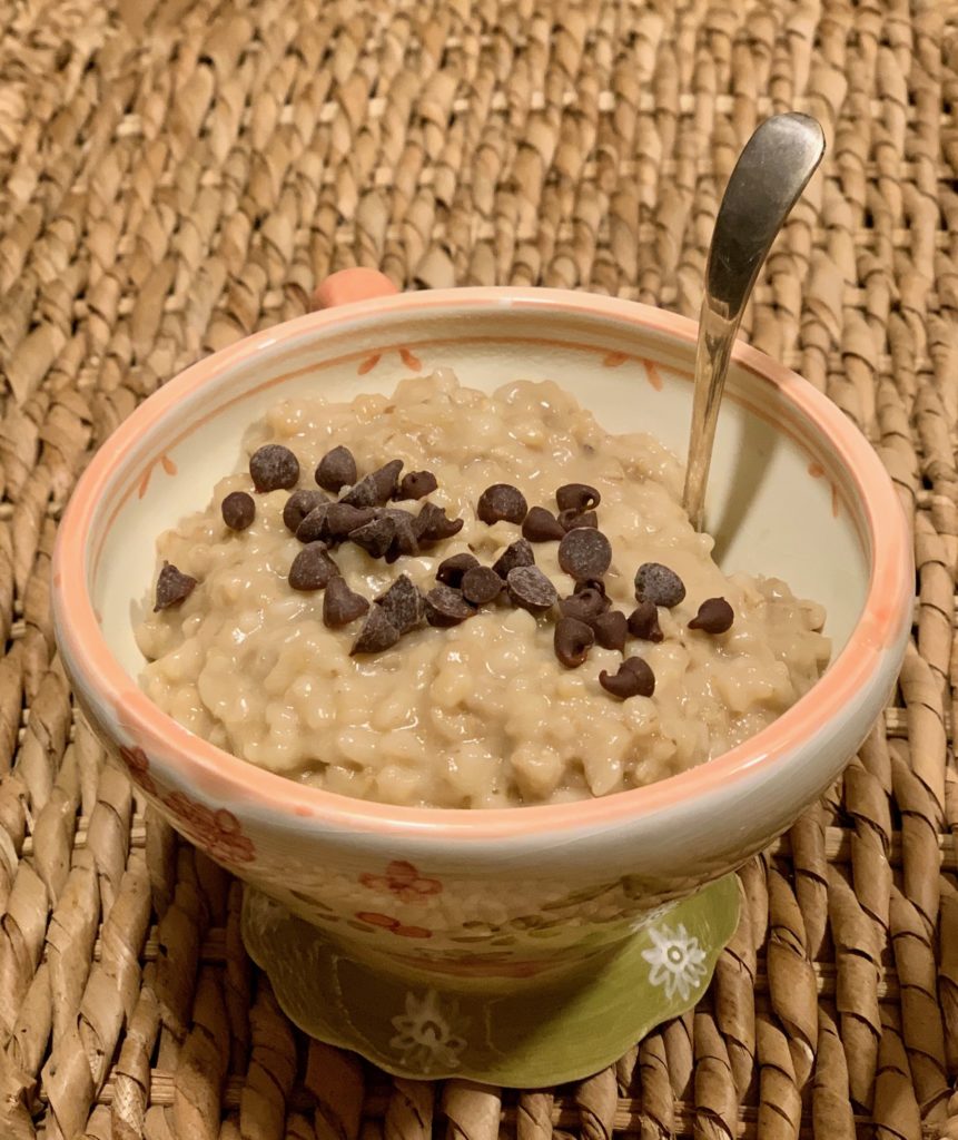 Oatmeal in a bowl with a spoon with chocolate chips sprinkled on top