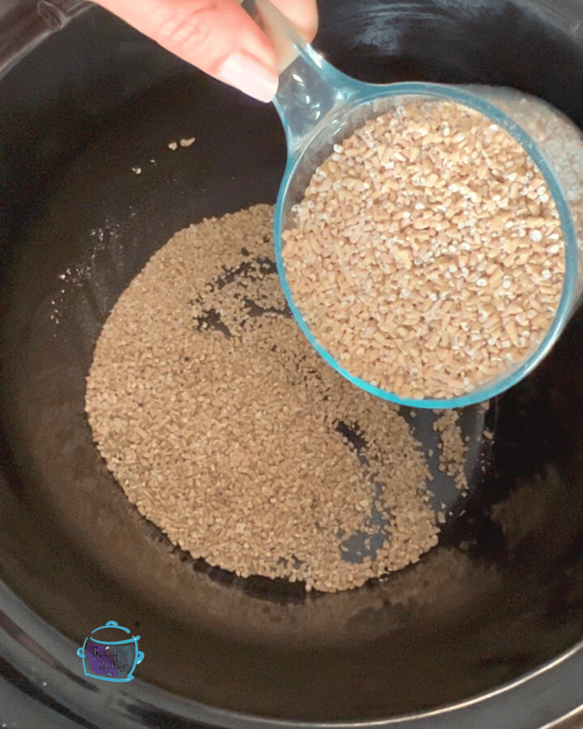 dry oatmeal being poured from a measuring cup into a crockpot