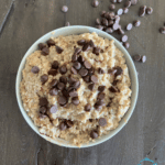 a round bowl filled with slow cooked oats sprinkled with chocolate chips