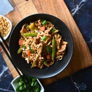 Slow cooker thai peanut chicken with noodles in a round black bowl