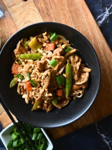 Slow cooker thai peanut chicken with noodles in a round black bowl