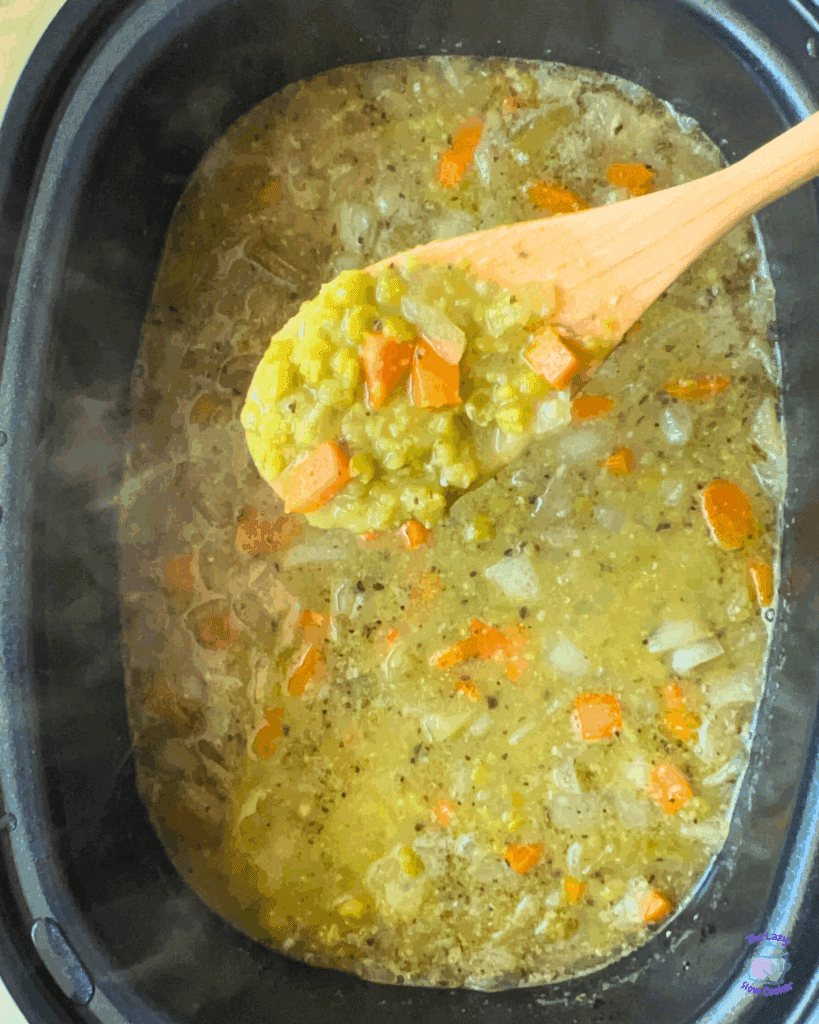 crockpot vegetarian pea soup after cooking on a wooden spoon