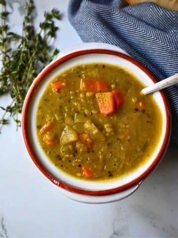 a round bowl with a spoon containing slow cooker vegan pea soup