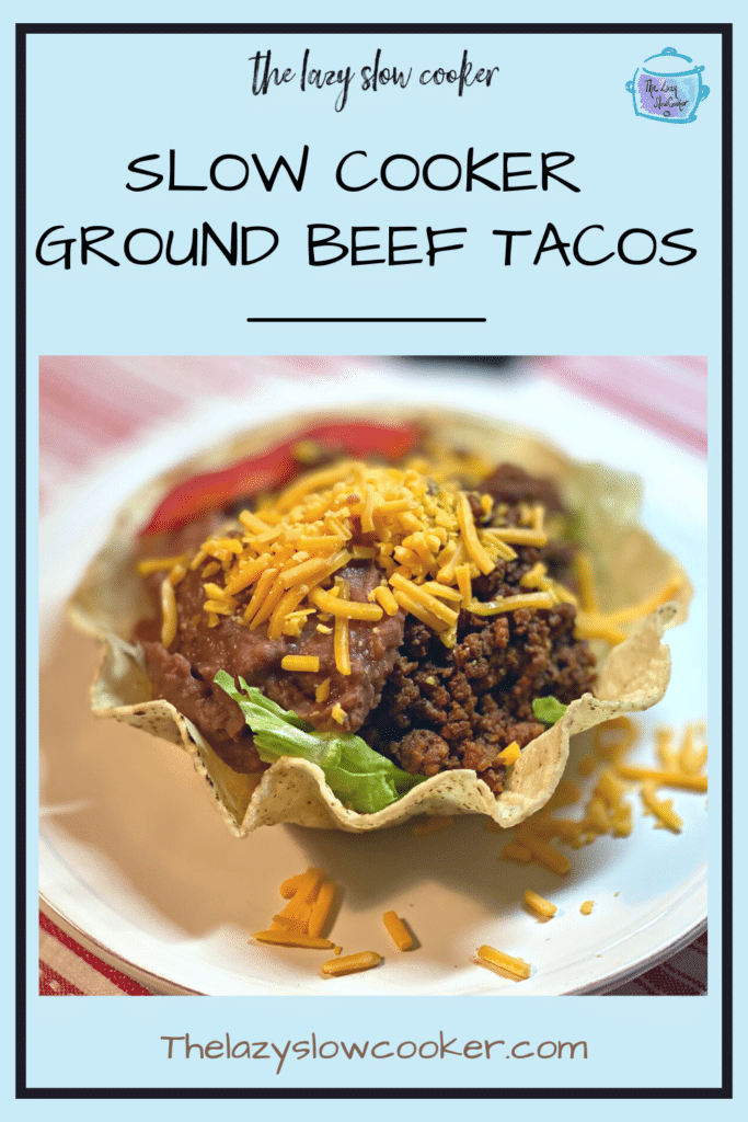 slow cooker ground beef taco meat in a taco shell bowl topped with cheese