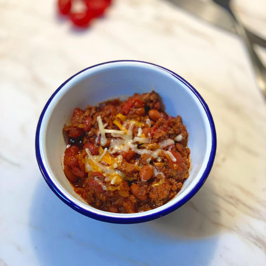 top view of chili in a bowl with some cheese on top