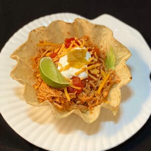 Top view of taco bowl with chicken and toppings.