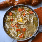 a grey bowl full of slow cooker lemon chicken and rice soup