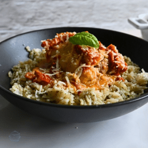 chicken in a creamy sun sun-dried tomato sauce in a bowl on top of rice