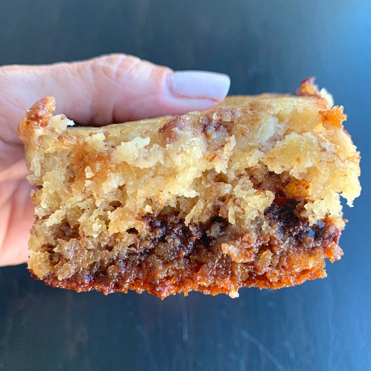 close up of a banana chocolate chip brownie being held by a human hand