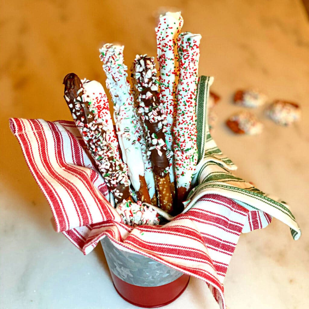 Pretzel rods dipped in white chocolate and colorful candy pieces