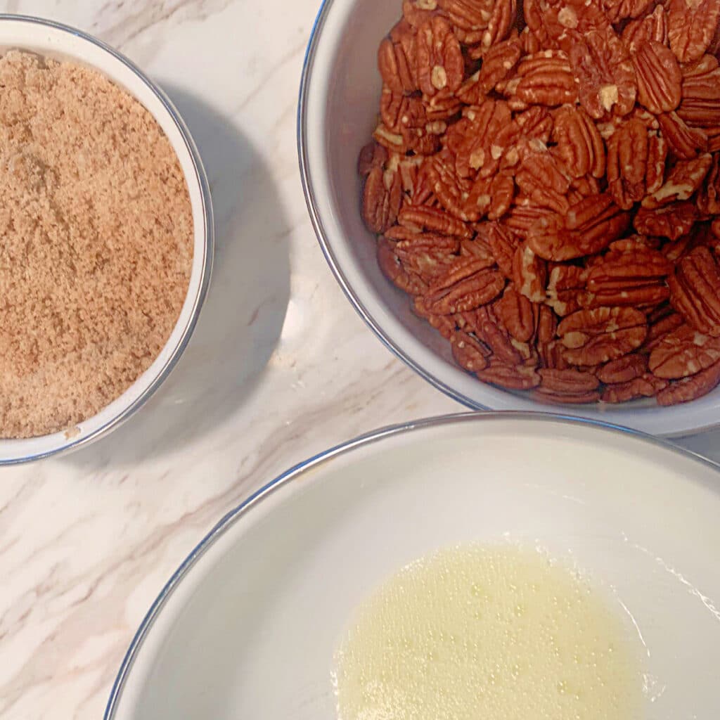 3 different sized round bowls on a marble surface each containing different ingredients that will be mixed together