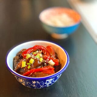 finished dish in around blue and white blow with a blurry image of rice in the background