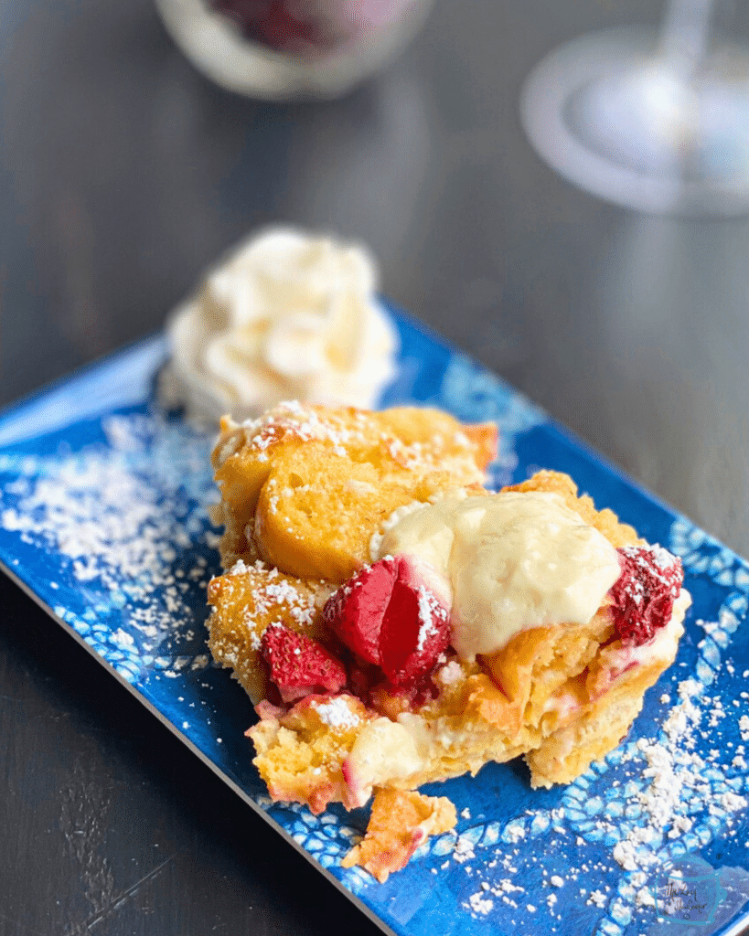 Slow cooker strawberry cheesecake French toast on a blue plate with whipped cream