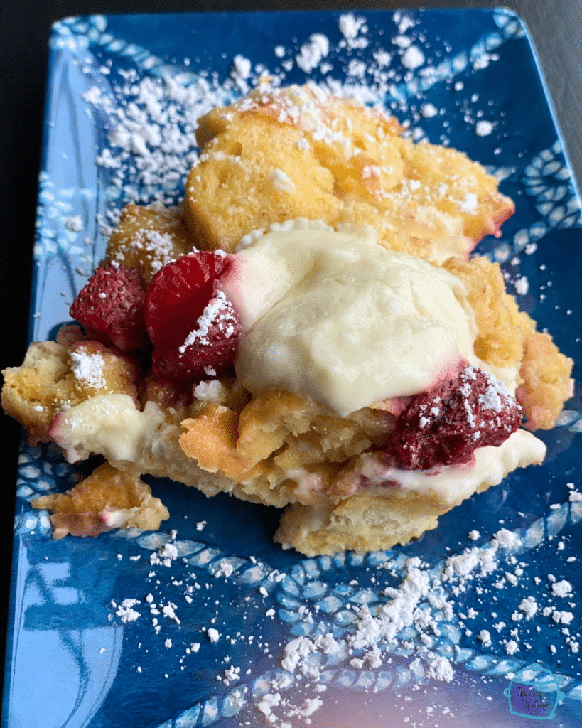 Slow cooker strawberry cheesecake French toast on a blue plate with whipped cream