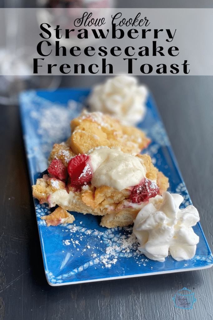 slow cooker strawberry cheesecake french toast on a blue plate with whipped cream dollops,
