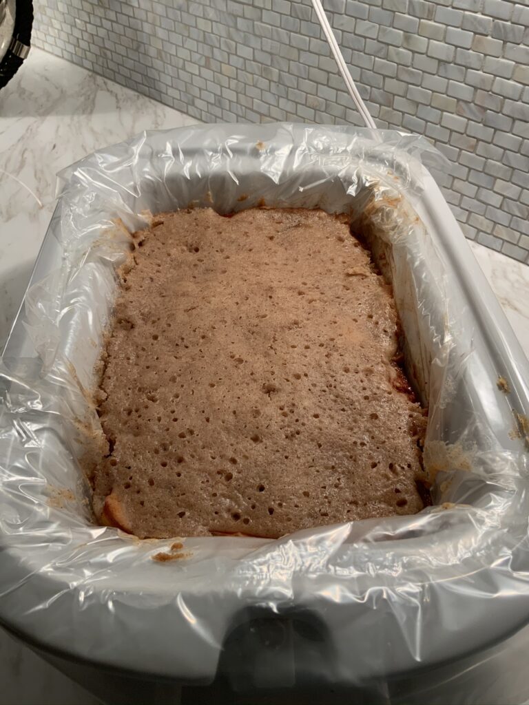 view of finished cobbler in casserole crockpot lined with a slow cooker liner