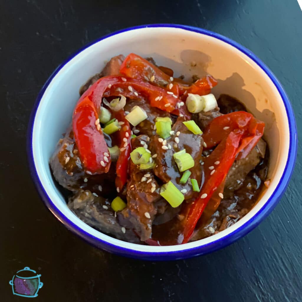 A bowl of Mongolian beef topped with green onion