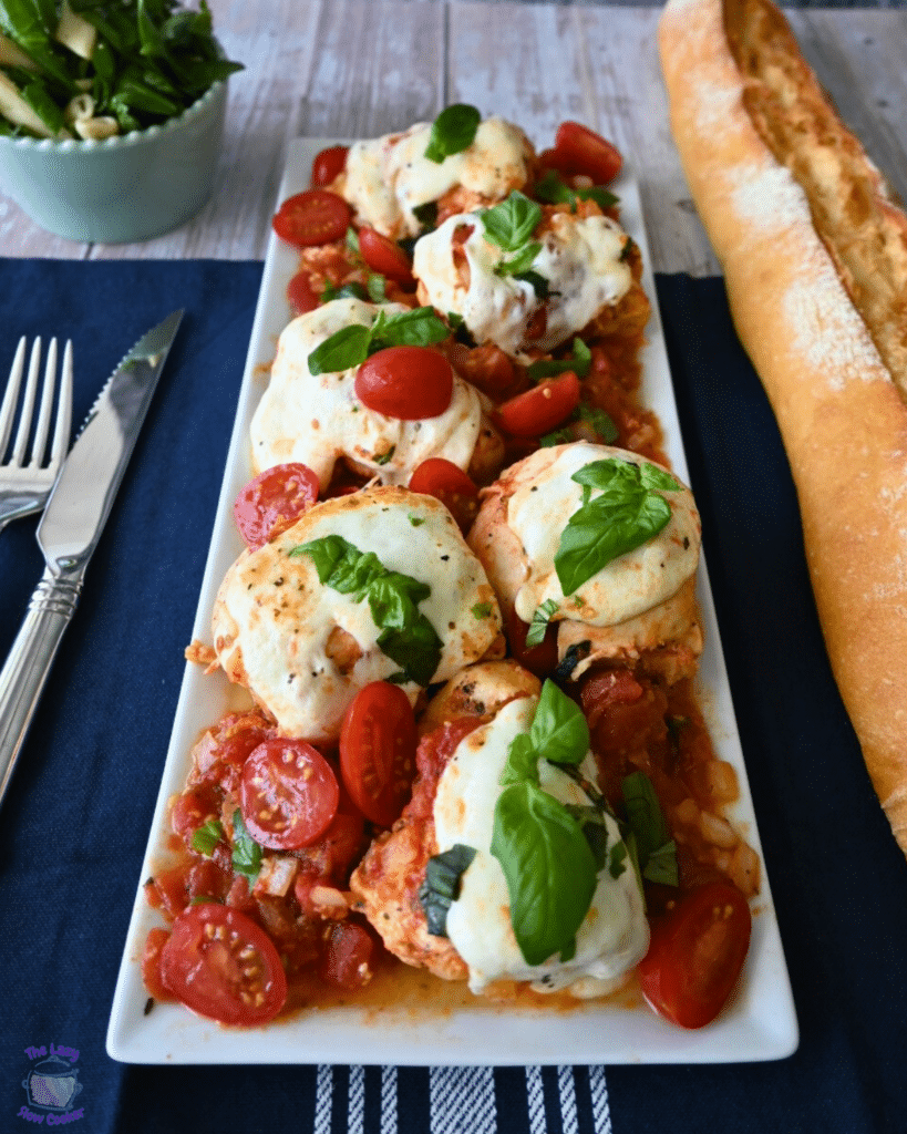 chicken caprese on a spatula over a serving plate full of the same