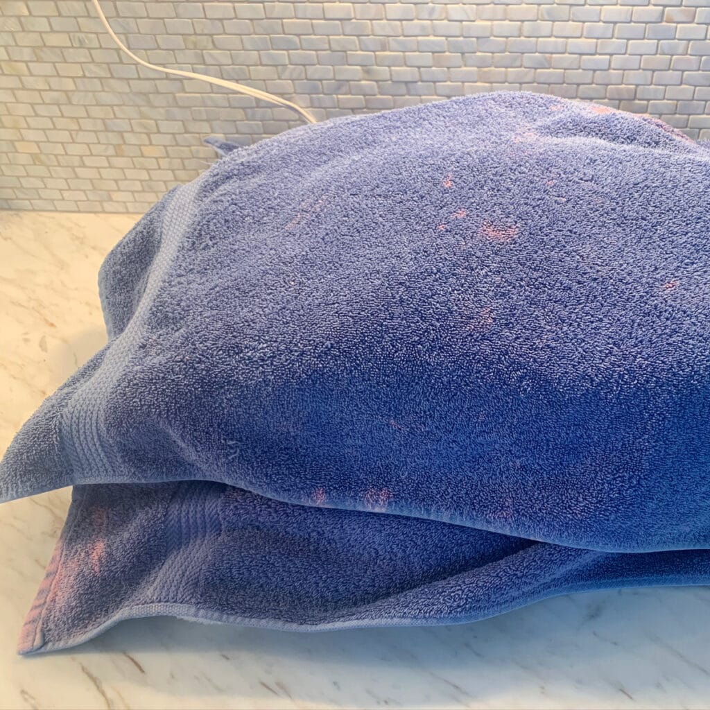 slow cooker covered in an old stained blue towel