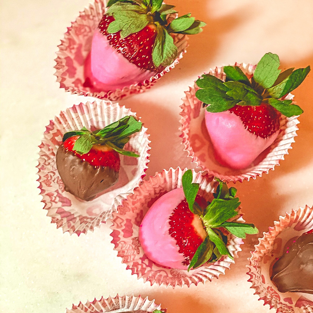 strawberries dipped in pink white and milk choclate